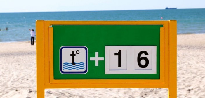 Ein Schild zeigt die Wassertemperatur am Strand an.